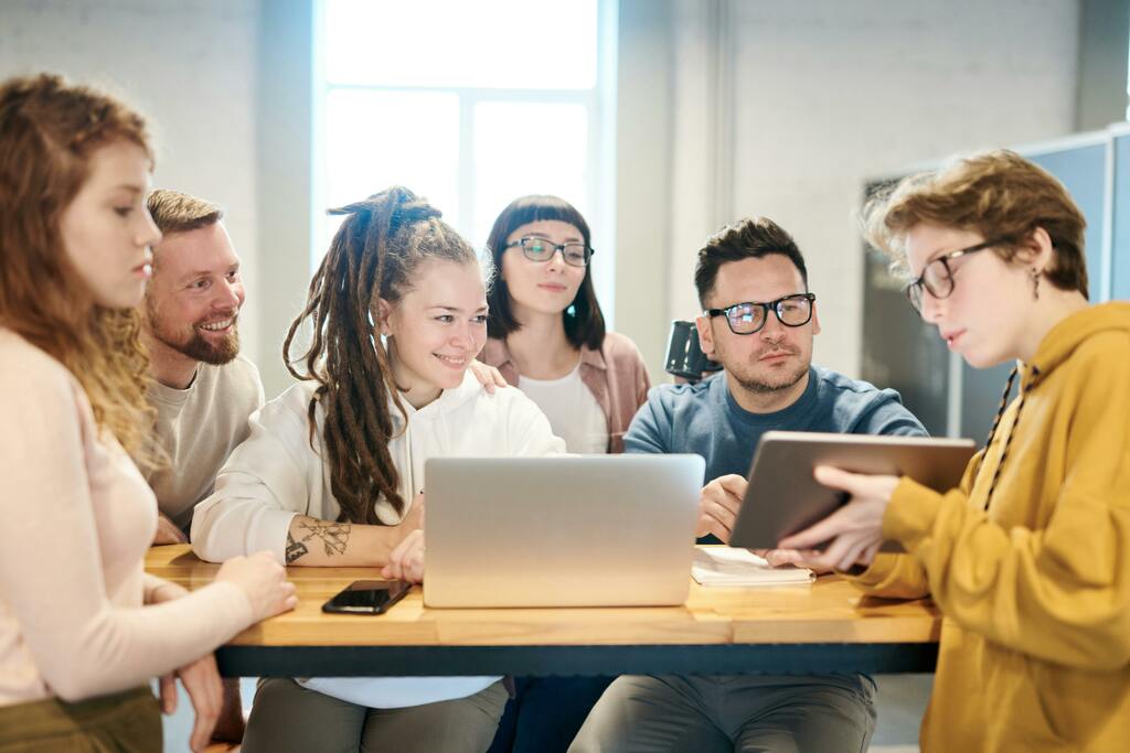 ein Gruppe junger Lernender am Computer, symbolisch für interaktiven und Unterricht in Deutschkursen, der Spass macht.